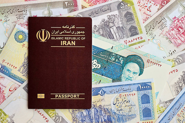 Passaporte vermelho da República Islâmica do Irã e iraniano reais contas de dinheiro fundo close up. Turismo e conceito de viagem - Foto, Imagem