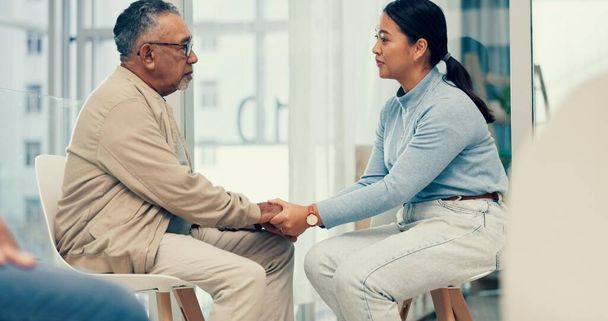 Support, psychologist or old man holding hands for help, empathy or compassion in therapy together. Trust, sympathy or therapist with senior person listening, talking or healing a loss in counselling. - Photo, Image