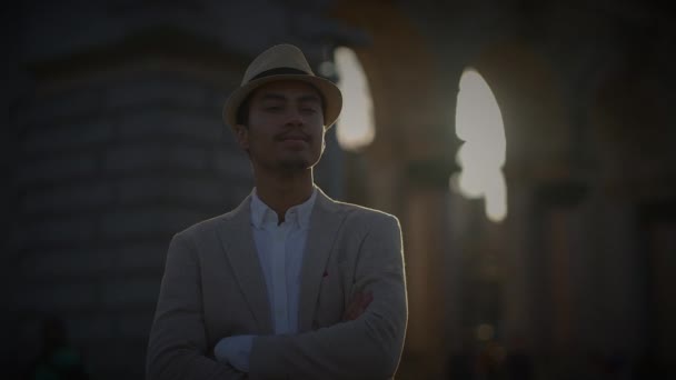 Модний молодий красивий чоловік у капелюсі та повсякденному одязі в місті - Кадри, відео