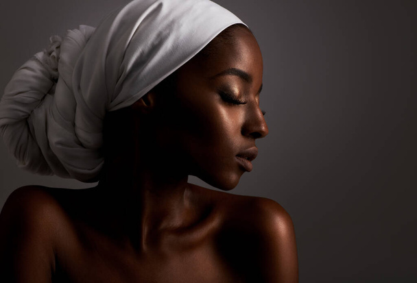Piękno, profil i czarna kobieta w ciemnym studio z chustą na głowie, pielęgnacją skóry i dumą z kultury. Kosmetyki, blask skóry i twarz afrykańskiej modelki z dermatologią, luksusem i dziewczyną na szarym tle. - Zdjęcie, obraz