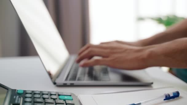 Close-up van de handen van de mens typen op de laptop computer toetsenbord voor werk thuis. Werk vanuit huis concept. - Video