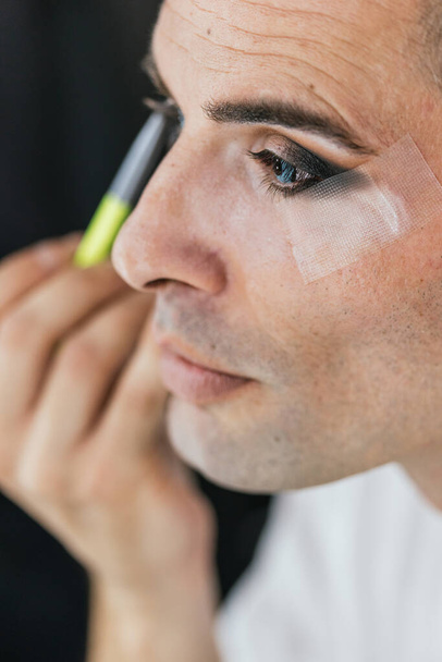 Close up view of a man doing his makeup. LGBT concept. - Photo, Image