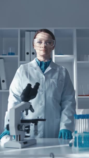 Um cientista químico realiza uma análise de um líquido em um laboratório para identificar possíveis impurezas ou contaminantes. O cientista posa para a câmara, aperta as mãos. Químico em um científico - Filmagem, Vídeo