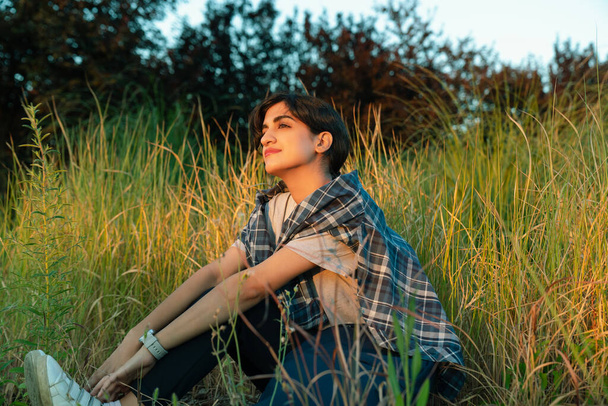 Young arab woman enjoying in nature, sitting on meadow - Photo, Image