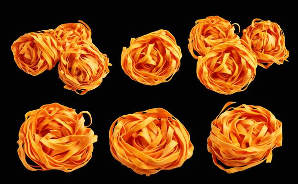 オレンジ イタリアのタグリタテルまたはフェッカチン パスタ古典的なスタック,クリッピング パスと隔離された巣の卵 イタリアのパスタ,黒い背景の影,調理の原料 - 写真・画像