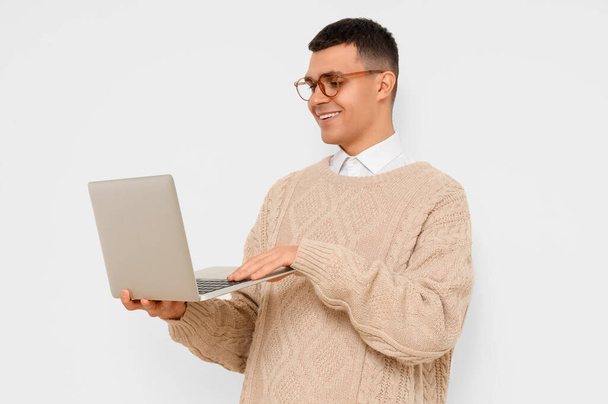 Auteur masculin utilisant un ordinateur portable sur fond clair - Photo, image