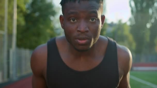 African American etniczny człowiek facet biegacz jogger sprinter działa na torze odkryty stadion sport grunt określony mężczyzna jogging rano trening biegać ćwiczenia poza miasto szybki ruch motywacja - Materiał filmowy, wideo