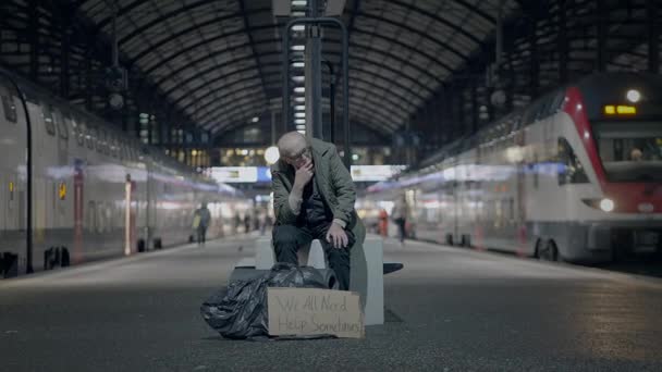 Грустный пожилой мужчина страдает от бедности пожилого возраста, будучи одиноким на вокзале - Кадры, видео