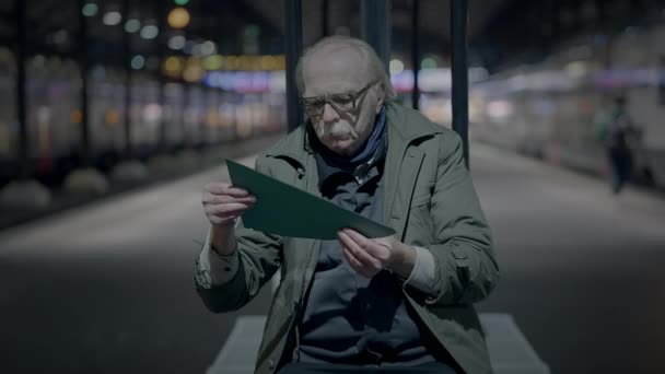 Грустный пожилой мужчина страдает от бедности пожилого возраста, будучи одиноким на вокзале - Кадры, видео