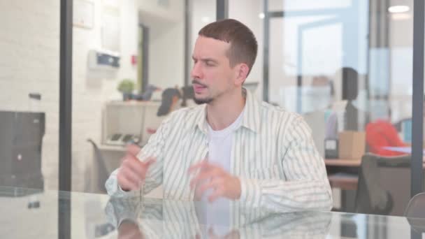 Rozzlobený kreativní mladý muž sedí v kanceláři - Záběry, video