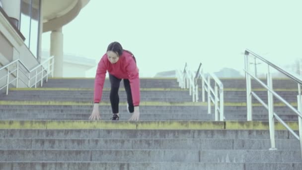 mladá dívka ve sportovním oblečení cvičení na schodech - Záběry, video