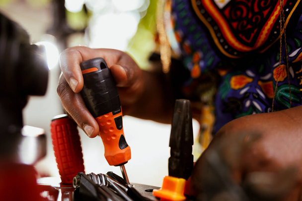 Nahaufnahme von afrikanisch-amerikanischen Händen, die Fahrradwerkzeuge aus dem professionellen Werkzeugkasten für Wartung und Reparatur greifen. Detailliertes Bild der individuellen Anordnung spezialisierter Anlagen. - Foto, Bild