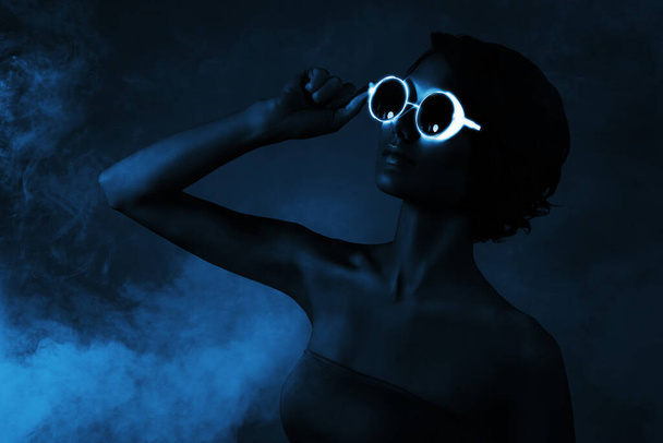 tendance créative collage de magnifique fille porter des lunettes de soleil cyberpunk fête nuit néon bleu foncé couleur fond. - Photo, image