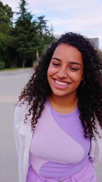 Šťastná mladá latinskoamerická dívka se usmívá na kameru stojící na City Street. Mimo vertikální portrét radostné krásné ženy nad městským pozadím. Video HD obrazovky. - Záběry, video