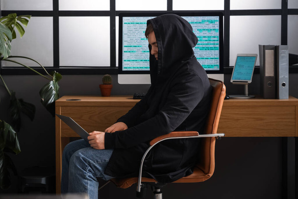 Hacker χρησιμοποιώντας φορητό υπολογιστή στο δωμάτιο - Φωτογραφία, εικόνα