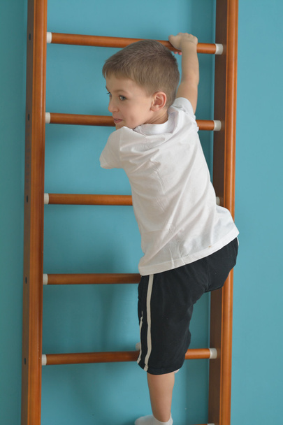 boy in the gym climbing the ladder - Фото, зображення