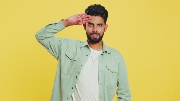 Yes sir. Subordinate responsible serious Indian man giving salute listening to order as if soldier, following discipline, obeying, expressing confidence. Arabian Hindu guy on yellow studio background - Footage, Video