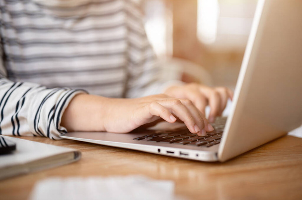Dizüstü bilgisayarında çalışan, dizüstü bilgisayarında klavyesini yazan bir kadının yakın plan fotoğrafı. İnsanlar ve kablosuz teknoloji kavramları - Fotoğraf, Görsel