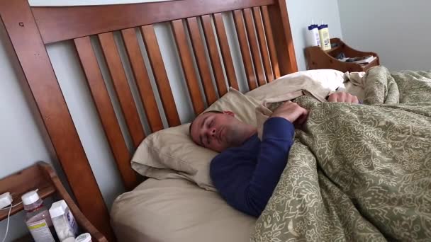Sick man lying in his bed - Footage, Video