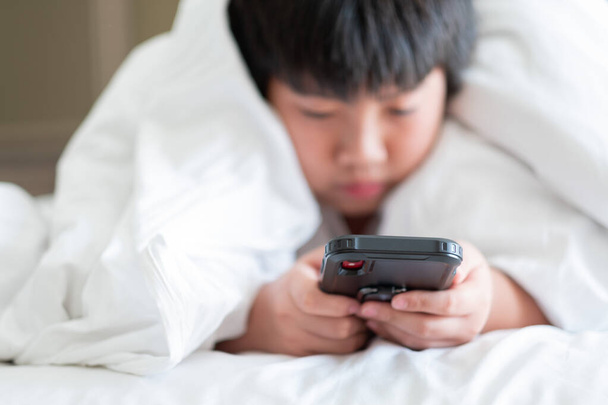 asiático chino chico jugando smartphone, niño uso teléfono y jugar juego, adicto juego y cartoo - Foto, imagen