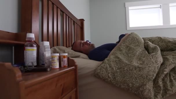 Sick man lying in his bed - Imágenes, Vídeo