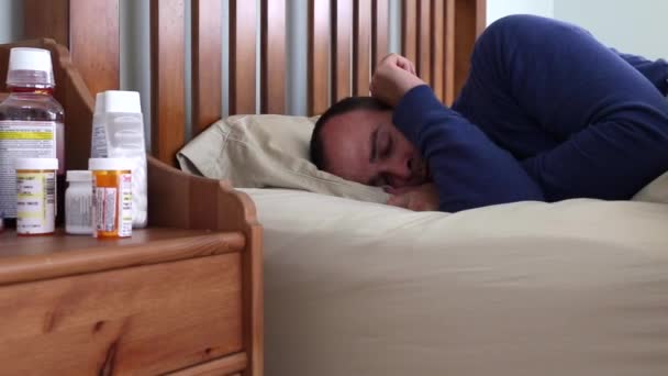 Sick man lying in his bed - Filmati, video