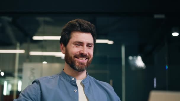 Relaxed caucasian man in denim shirt leaning on back and putting hands behind head with satisfied smile. Successful remote worker finishing important business project and feeling glad with result. - Footage, Video