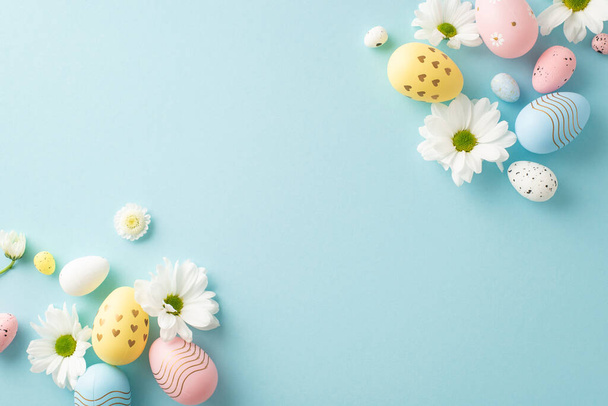 Idée de conception de Pâques : Vue aérienne des œufs pastels et des fleurs de camomille sur un fond bleu doux avec de l'espace pour votre message ou votre promotion - Photo, image