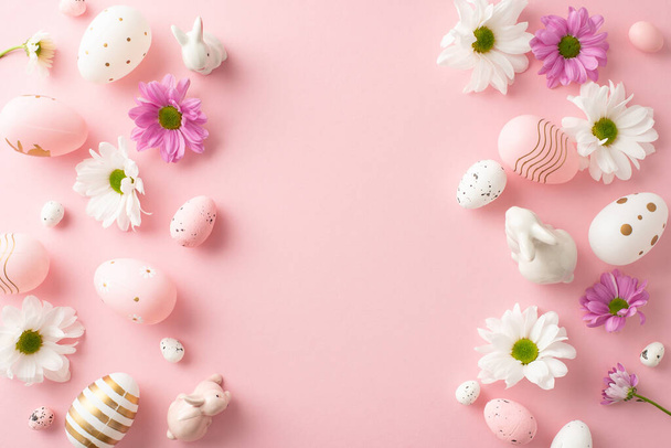 Festive Easter concept from top view: eggs, ceramic bunnies, chrysanthemums on a pastel pink background, with space for text or adverts - Photo, Image
