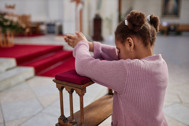 Африканська американська дівчинка стоїть за вівтарем і молиться в церкві - Фото, зображення