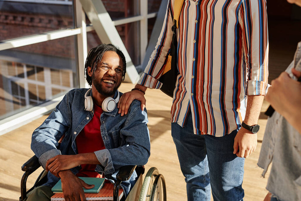 Africký americký student se zdravotním postižením mluvit se svými spolužáky během přestávky na vysoké škole - Fotografie, Obrázek