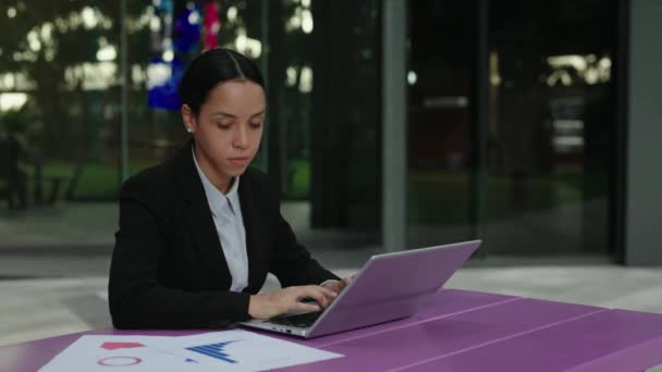 Young Female Manager Trabalha em um computador, compara gráficos e entra em dados. Proprietário de negócios bem sucedido transfere informações de gráficos para um laptop. Conceito de Pessoas e Tecnologia - Filmagem, Vídeo