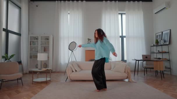 Egy nő élvezi a szabadidőt otthon zenét hallgatni és táncolni, boldog női lassított felvétel - Felvétel, videó