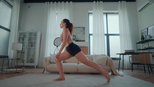 Bir kadın evde yoga yapıyor. Sağlıklı ve sağlıklı olmak için antrenman yapıyor. Kızıl saçlı kadın vücut esneme egzersizleri yapıyor.  - Video, Çekim