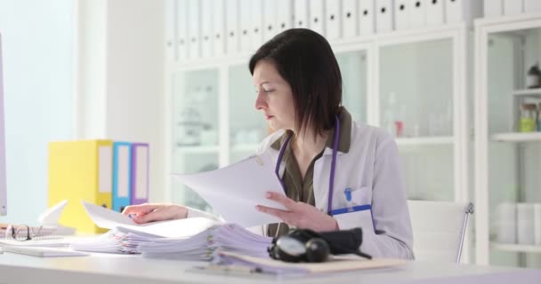 Mulher médico examinando o exame do paciente documentos de papel filme 4k câmera lenta. Papelada no conceito de medicina - Filmagem, Vídeo