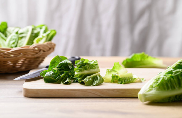 Organik çünkü ahşap tahtada romaine marulu, sağlıklı salata için gıda malzemesi. - Fotoğraf, Görsel
