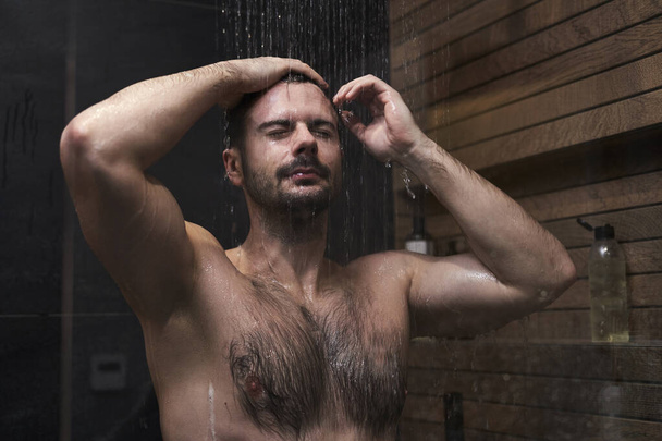 Кавказский мужчина принимает душ дома - Фото, изображение