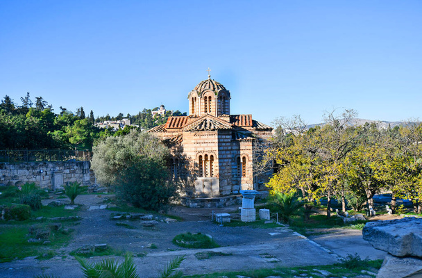 Athene, Griekenland - 19 december 2023: Heilige Kerk van de Heilige Apostelen van Solakis, gelegen in de oude Agora van Athene gedateerd aan het einde van de 10e eeuw, Nationaal Observatorium op de achtergrond - Foto, afbeelding