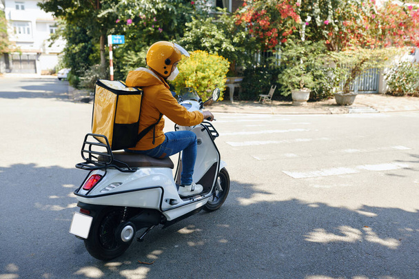 Entrega hombre en moto uniforme amarillo - Foto, imagen
