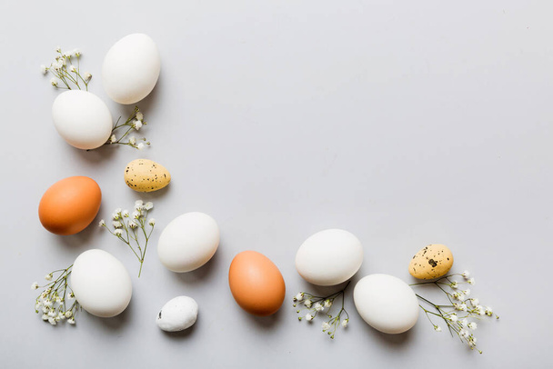 Buona composizione pasquale. Uova di Pasqua su tavolo colorato con gypsophila. Naturale colorato uova sfondo vista dall'alto con spazio copia. - Foto, immagini
