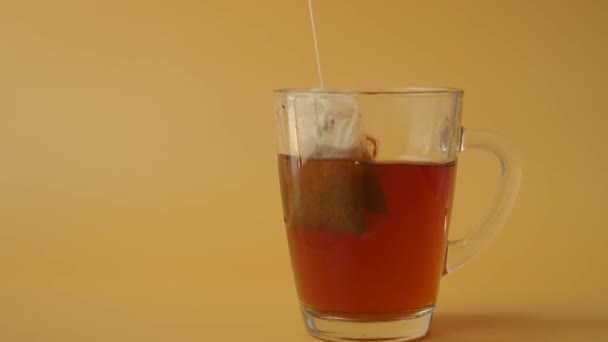 Tea táska egy fehér csésze teában. Reggeli teát készítek. - Felvétel, videó