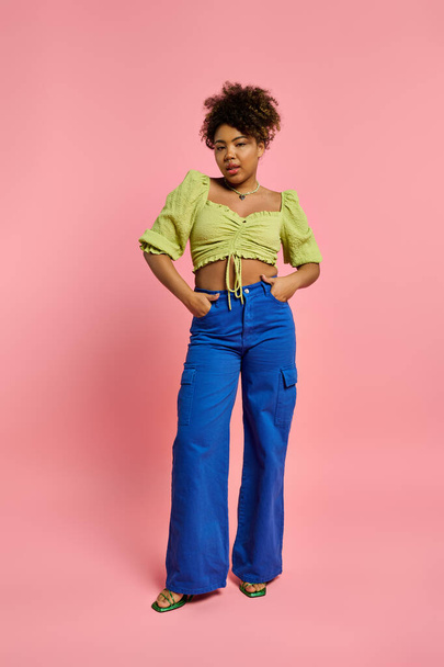 Stylish African American woman poses against vibrant pink backdrop. - 写真・画像