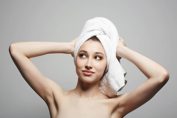 mujer joven y emocional con toalla en la cabeza. Hermosa chica sexy con cabello mojado después de la ducha - Foto, imagen