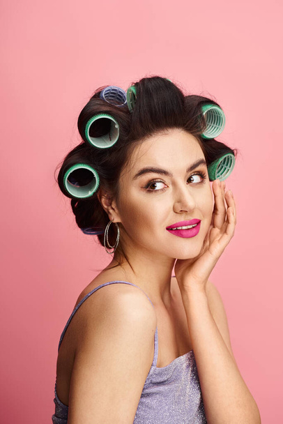 A stylish woman with curlers in her hair represents natural beauty on a vibrant backdrop. - Photo, Image
