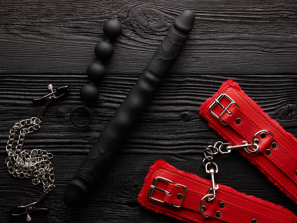 Dospělí BDSM hračky sada přes černé dřevěné pozadí - Fotografie, Obrázek
