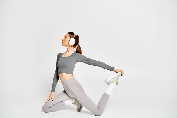 A sporty young woman in active wear working out in her headphones - Photo, Image