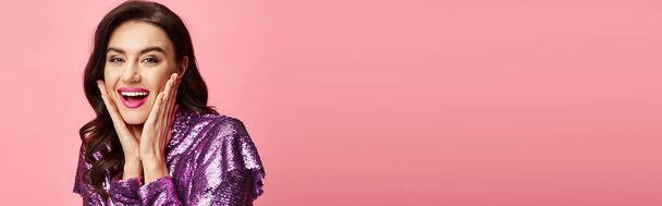 Una mujer con un vestido de lentejuelas púrpura toma una pose para la cámara. - Foto, imagen