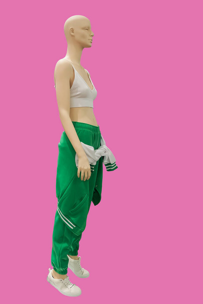 ピンクの背景に隔離されたファッショナブルなスポーツウェアを身に着けている女性のディスプレイマネキンの全長画像 - 写真・画像