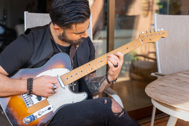 Hipster guitarist playing an electric guitar outdoors. - Photo, Image