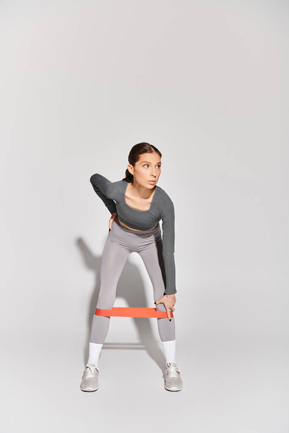 Sportowa młoda kobieta w aktywnym zużyciu ćwiczy z opaską oporową - Zdjęcie, obraz